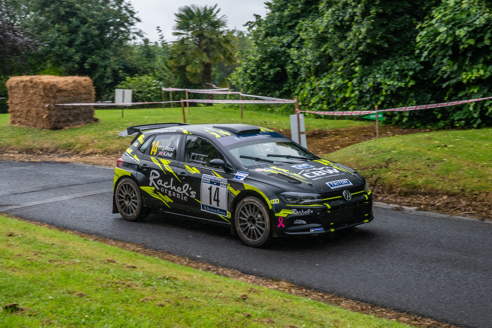 Rally car approaching on a forest tarmac stage
