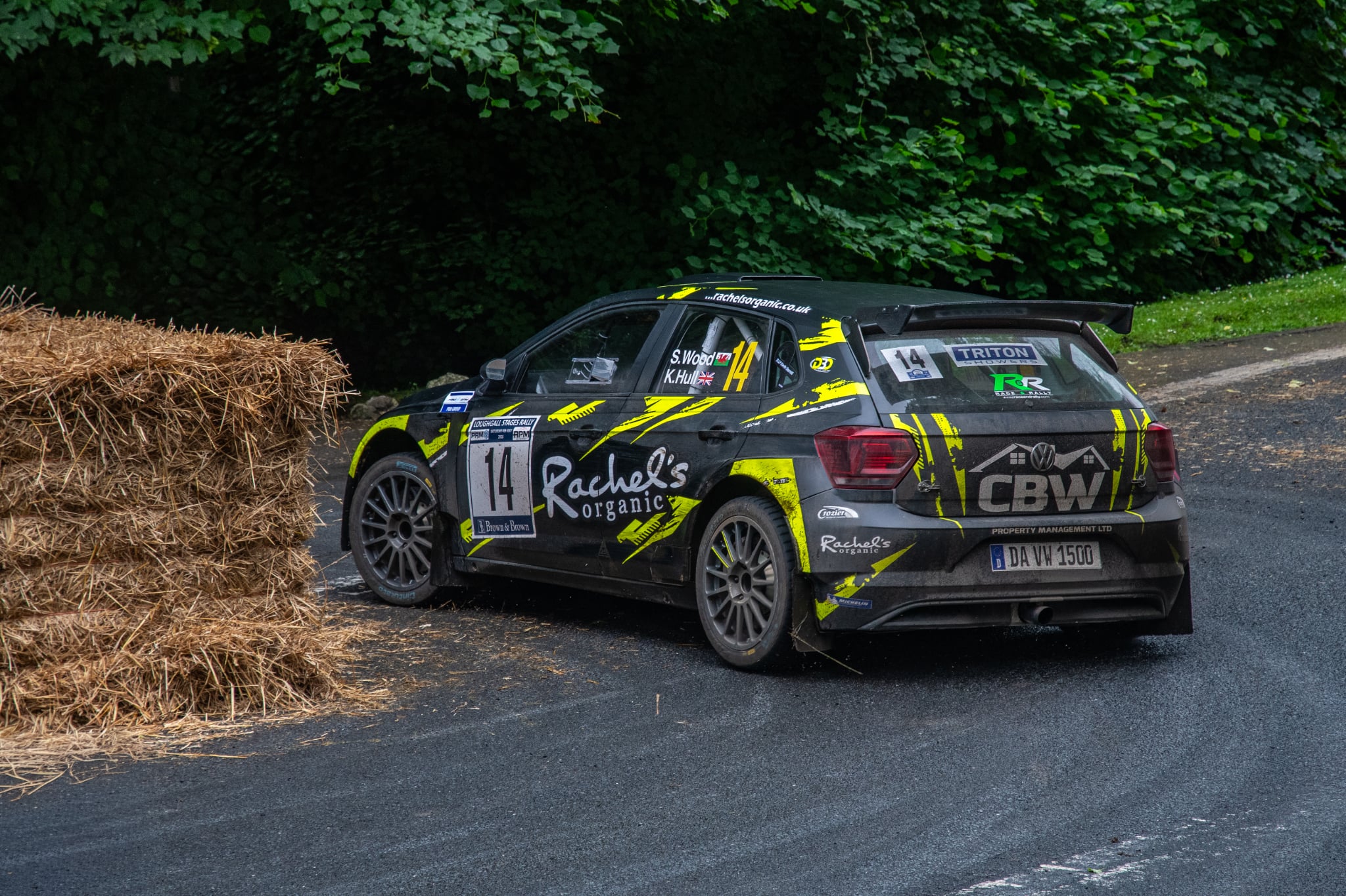 Rally car number 14 negotiating a tight tarmac hairpin